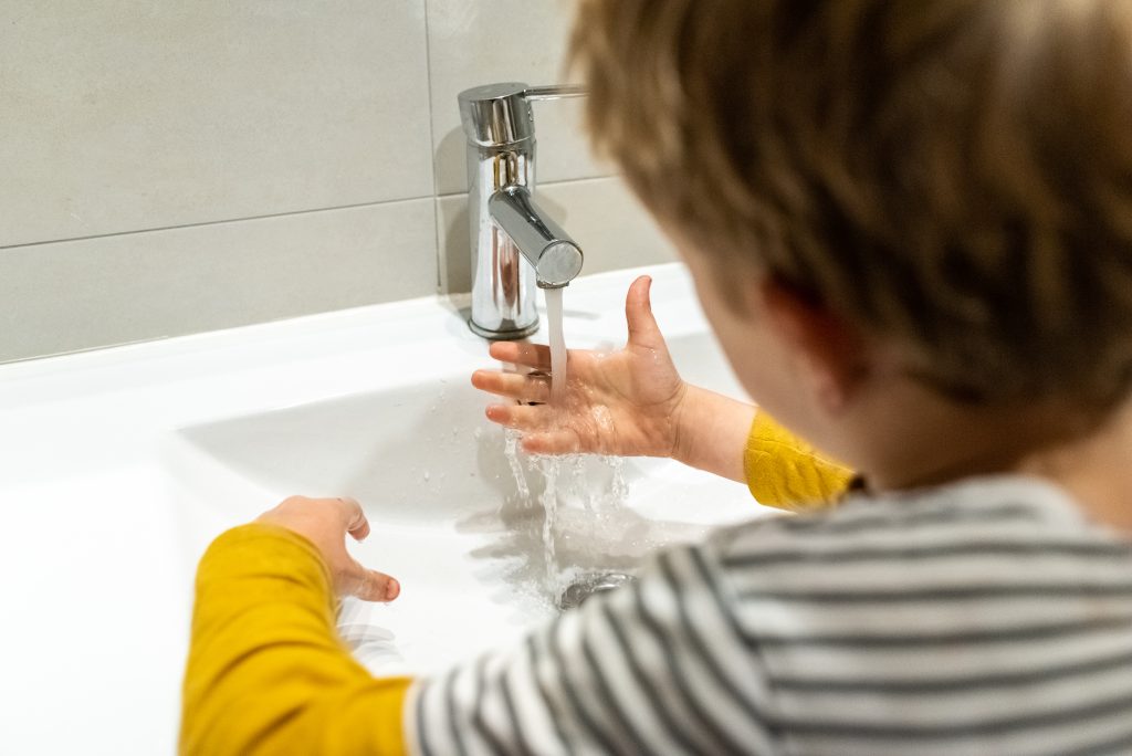 Niño lavándose las manos.